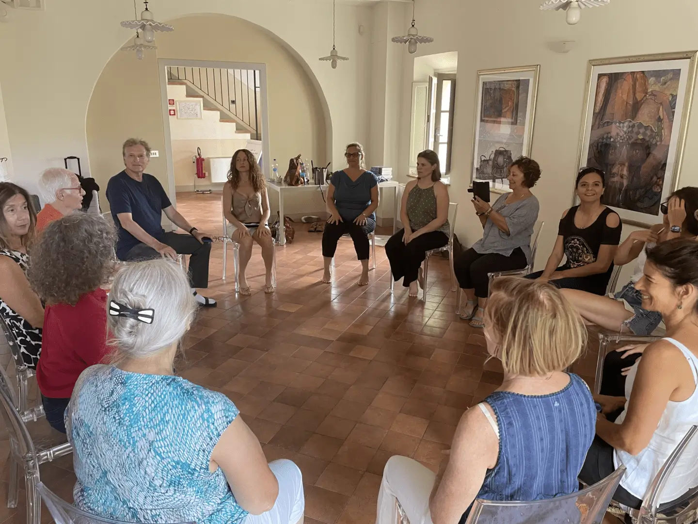 A group of people sitting in chairs around each other.